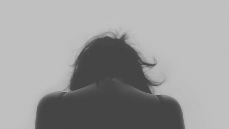 black and white image of back of young woman looking down