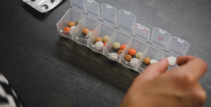 woman putting a pill into a pill organizer
