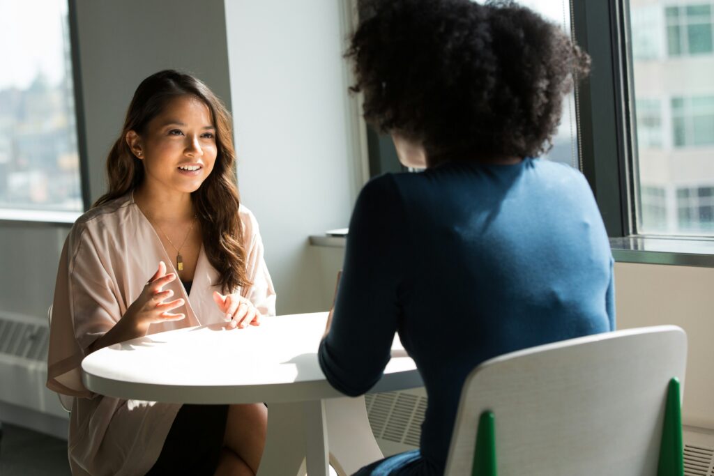 two young women in a meeting speaking to each other